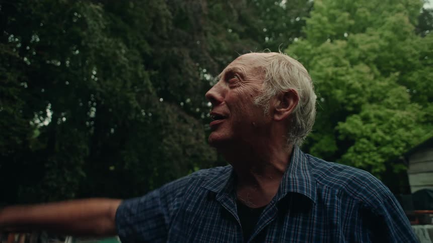 Portrait of an elderly man in an outdoor area with trees around talking
