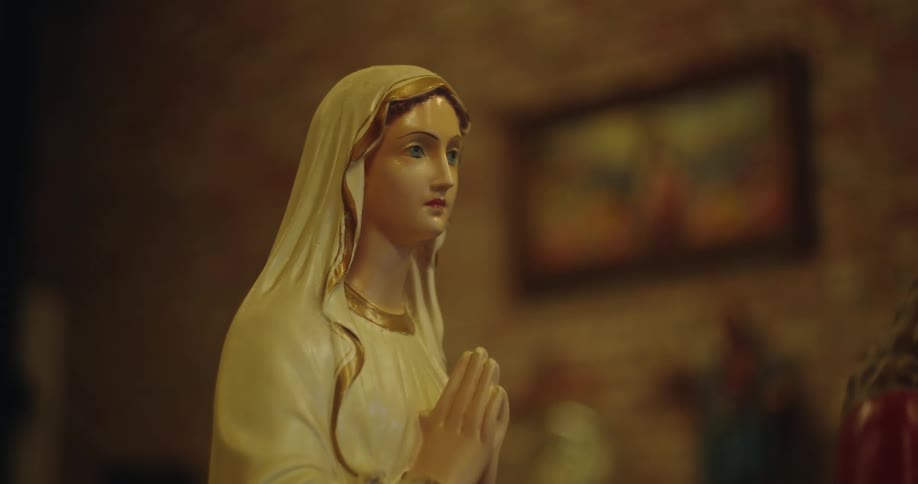 A religious porcelain statue of a woman in a head scarf while praying