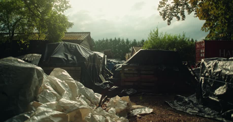 Debris on an outdoor lot covered by a black tarp