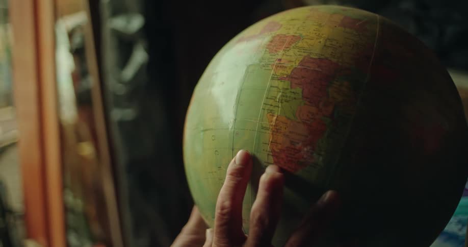 Hands of a person rotating a scientific globe