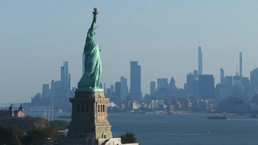The statue of liberty stands on the coast of new york city