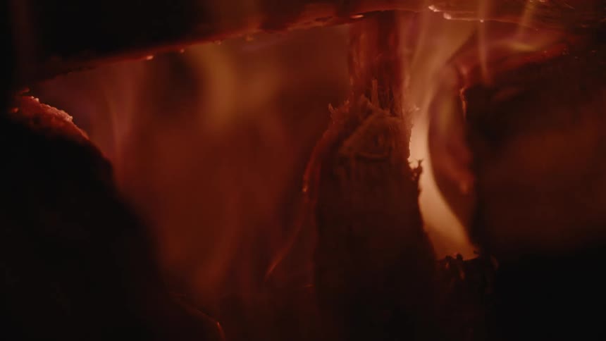 A close up of a fire with burning wood and flames