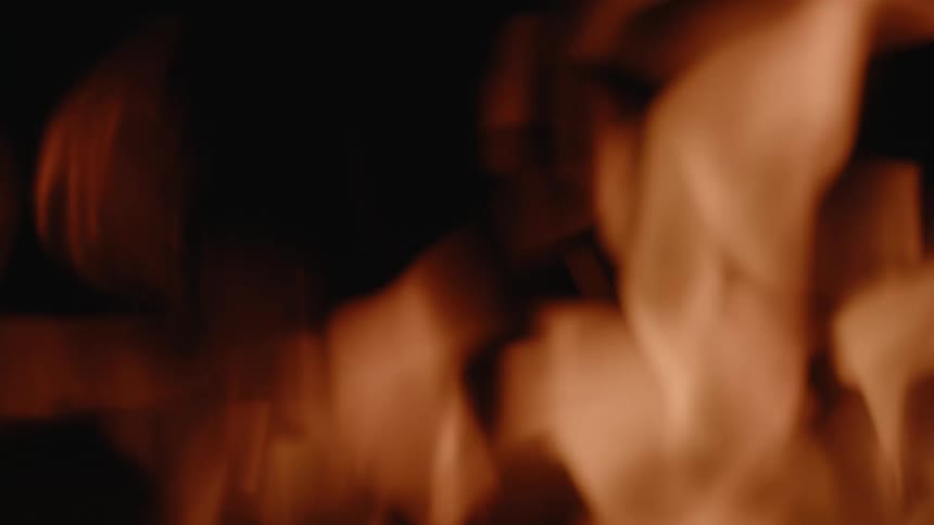 A fire burns outdoors at night