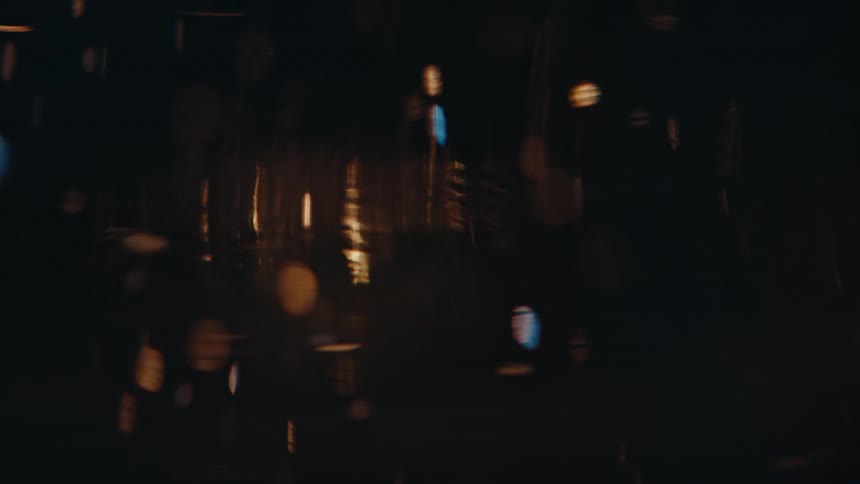 Closeup view of particles floating in a liquid with light reflecting through it creating an amber glow