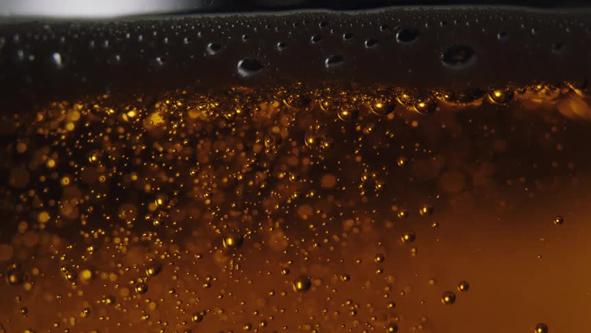 Gas bubbles inside beer rising up to the foam