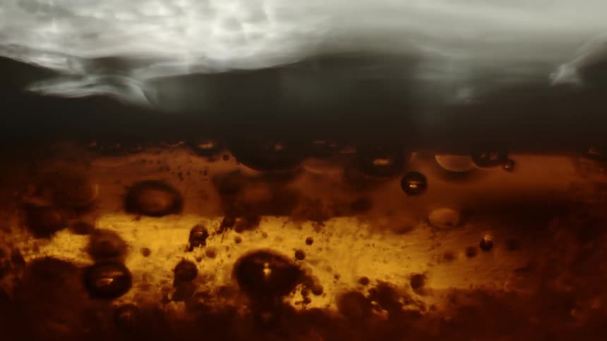 Gas bubbles inside beer rising up to the foam