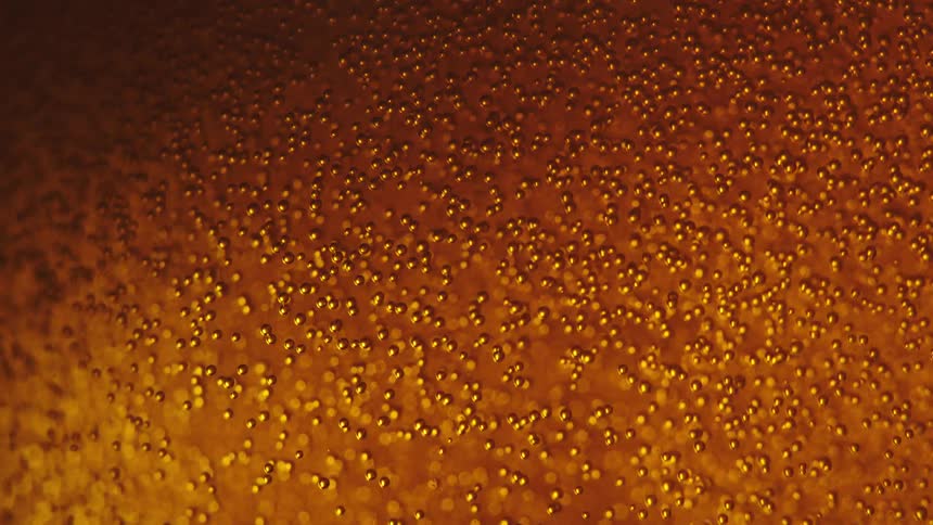 Bubbles rises through an amber alcoholic beverage