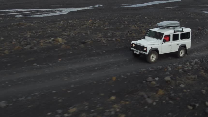 A vehicle is driving over some ground like mud and traveling to a spot
