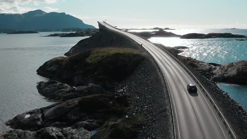 Car driving down a high road over the water