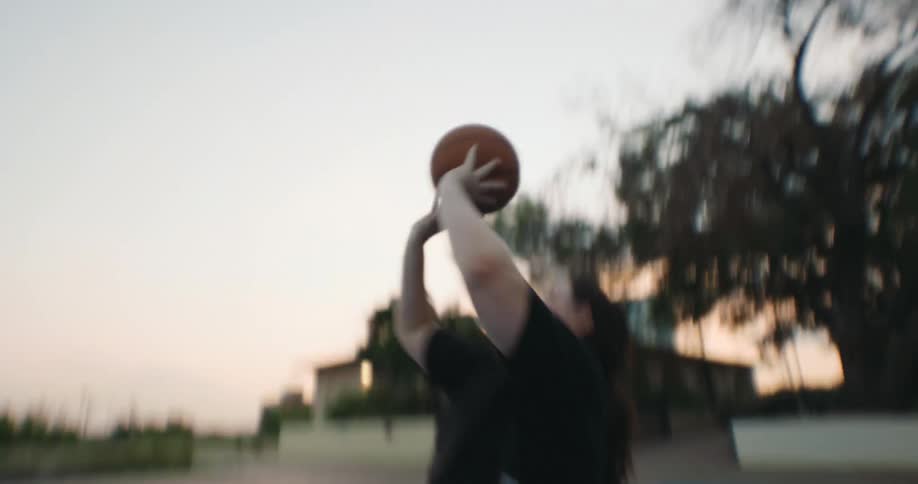 A female in a wheelchair plays basketball on a court