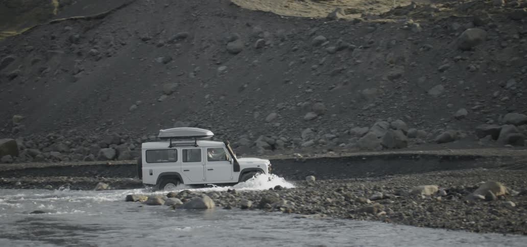 Vehicle moving through a shallow stream crossing their path