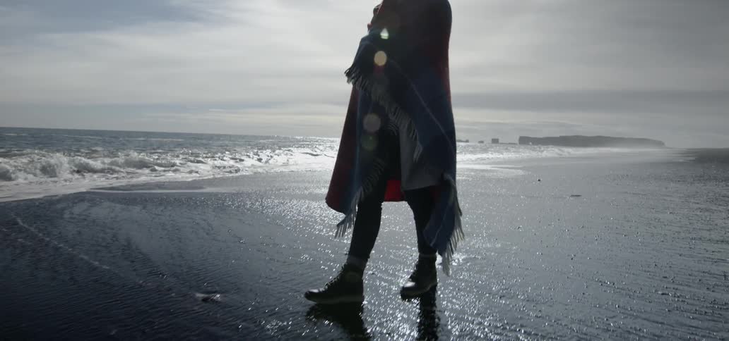 Woman walking along the beach on a sunny day