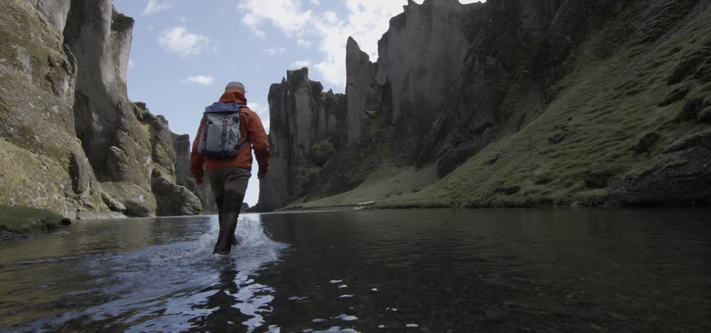 A man is walking through shallow water