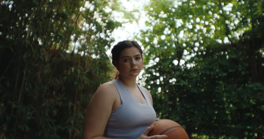 A girl in a wheelchair is holding a basketball