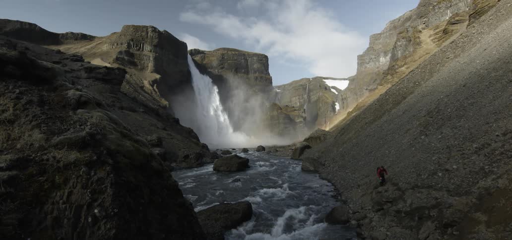 Large waterfall flowing into a rapidly moving  river