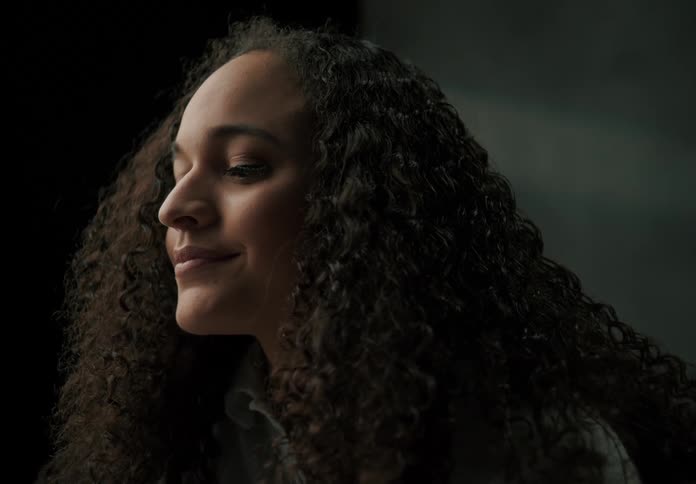 Close up of a womans face as she smile then looks down contemplatively