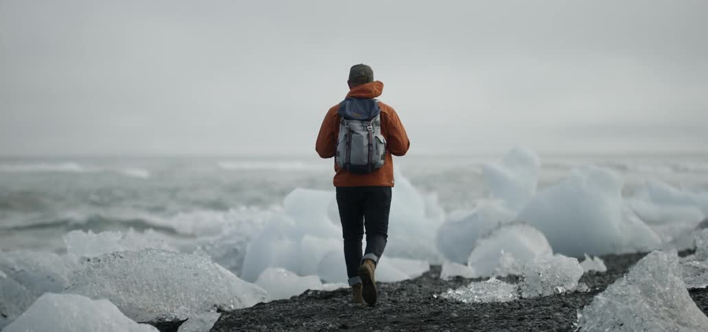 Hiker walking along an icy shore