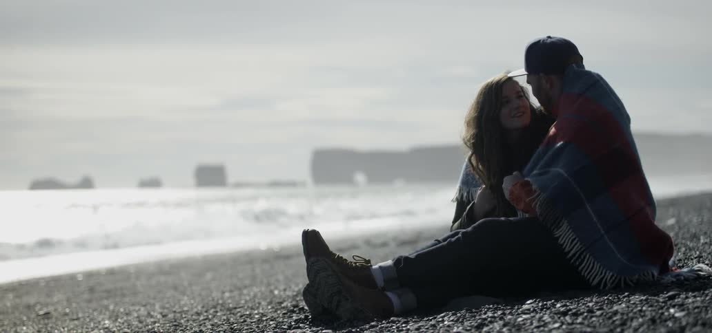 A couple kiss and cuddle on a beach