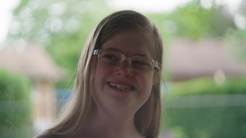 Close up of a smiling young blonde girl wearing glasses