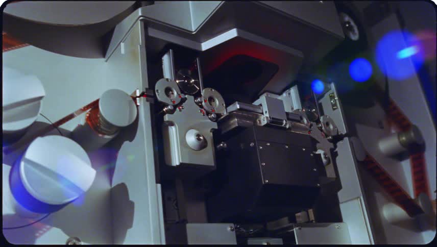 Closeup view of film threading equipment with cylindrical reels and components