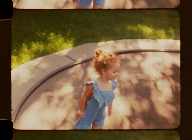 Children playing on a trampoline set into the grass in the backyard