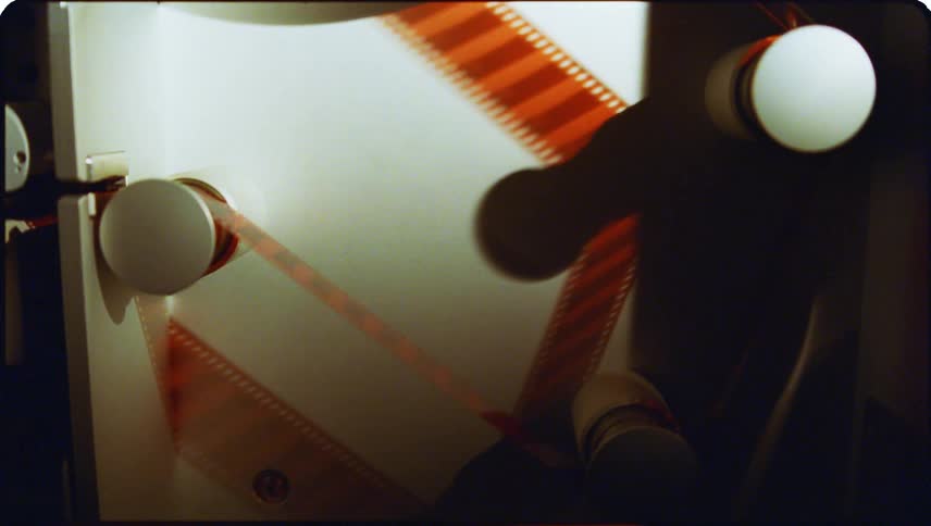 A machine rotating film through sliders as it casts shadow on the machine side
