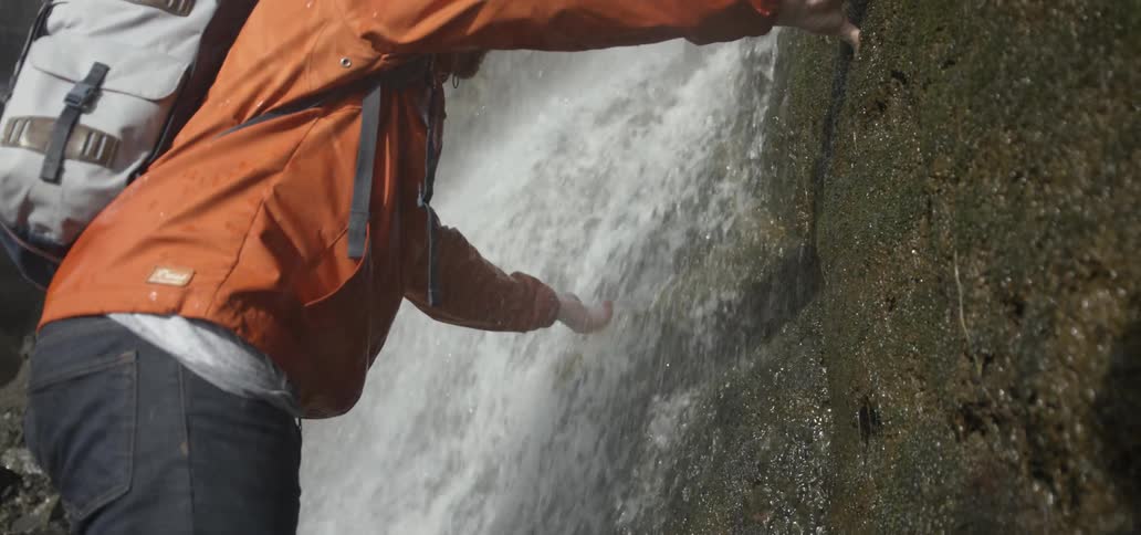 Man touching a waterfall