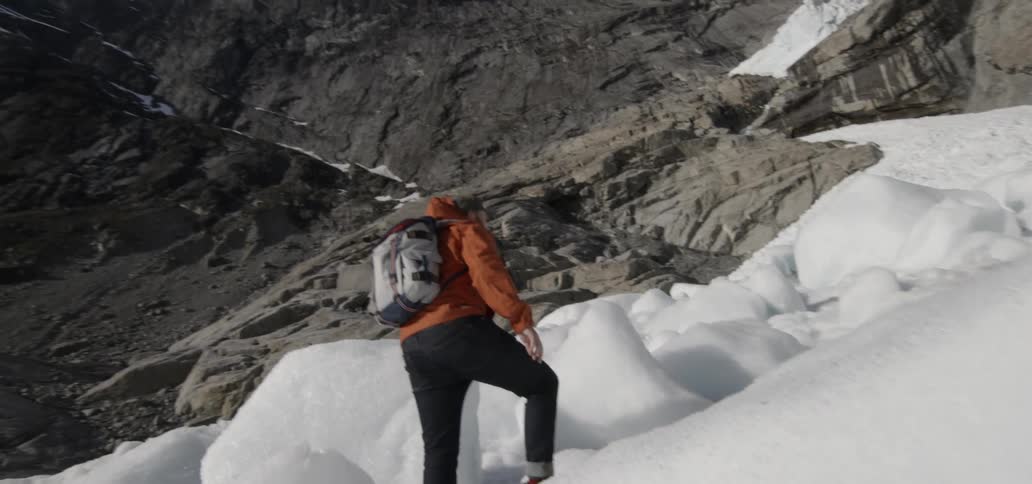 Hiker following a snowy path up a mountain