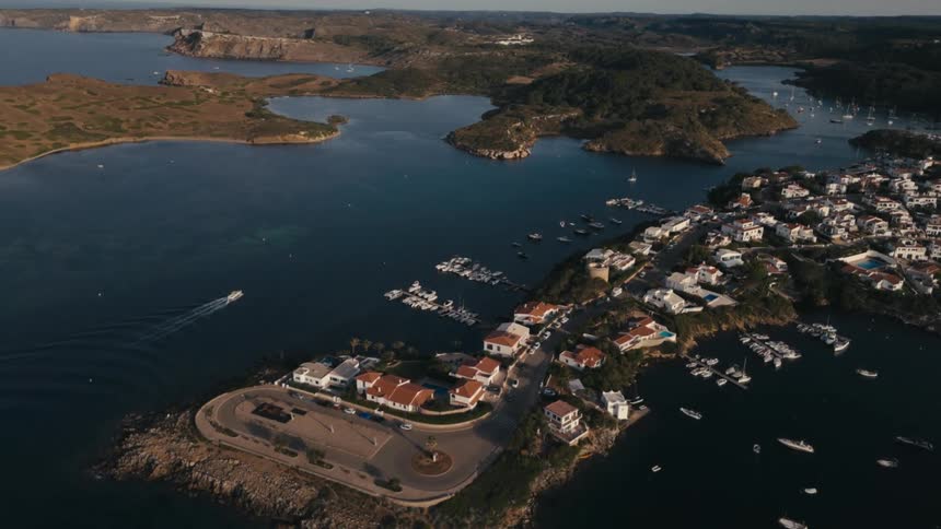 Boats float in the water near a peninsula occupied by a residential neighborhood
