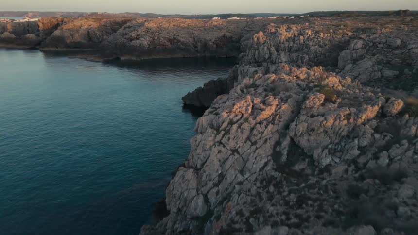 A rocky coast with the water of a bay connected to the sea on a clear day