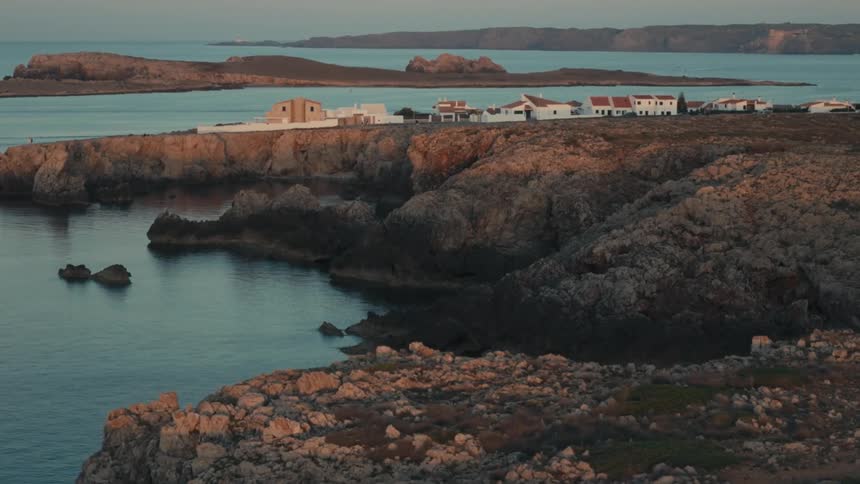 A small town on a rocky coast with a calm sea