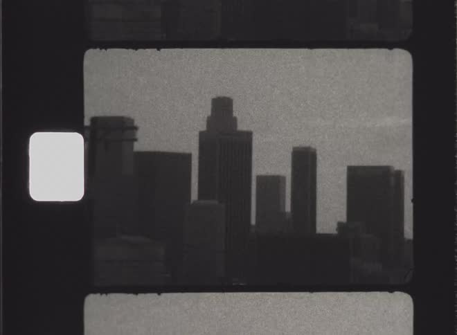 Traffic passes houses a distance from the downtown skyline