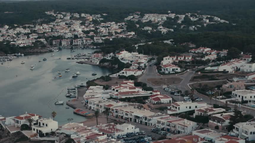 Aerial of condensed housing near a waterway full of boats