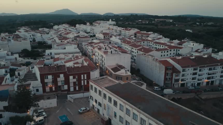 An aerial view of a quaint town with white buildings and red tile roofs