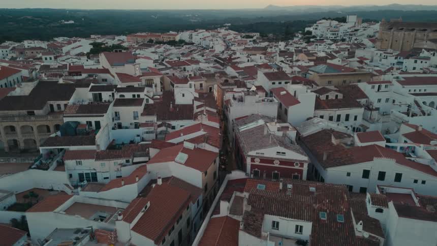 White buildings with red roofs fill a town containing a historic landmark building