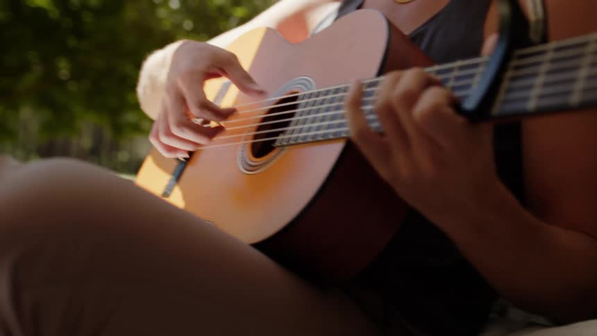 A person is playing a guitar outside