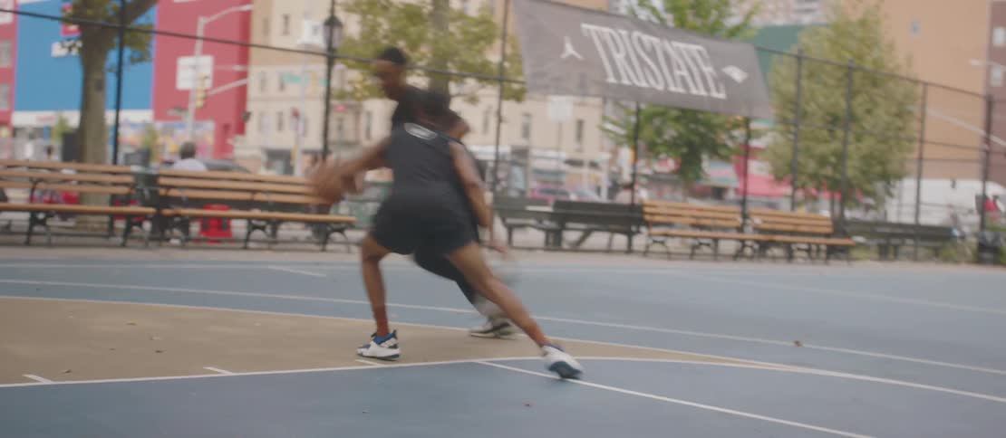 A clip of two males playing basketball