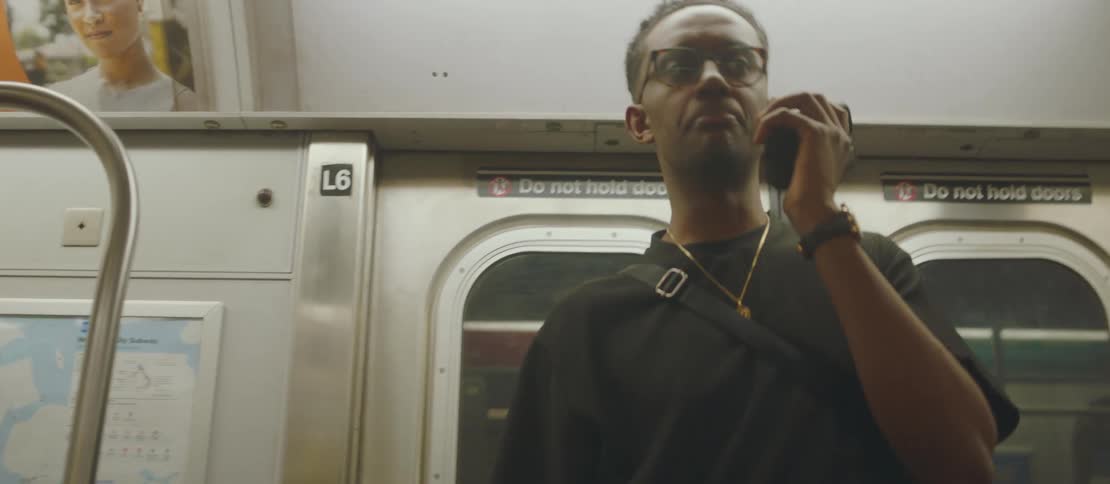 Man talking on a smartphone boards a subway train