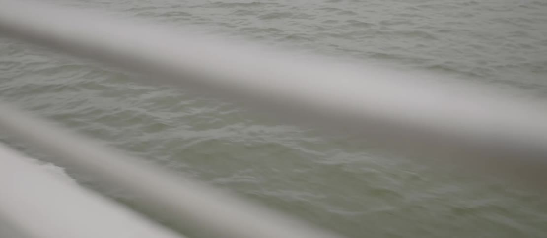 River water flows by a boat railing