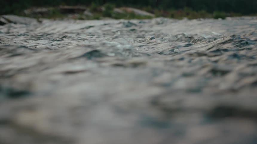Rushing river water splashes water drops into the air