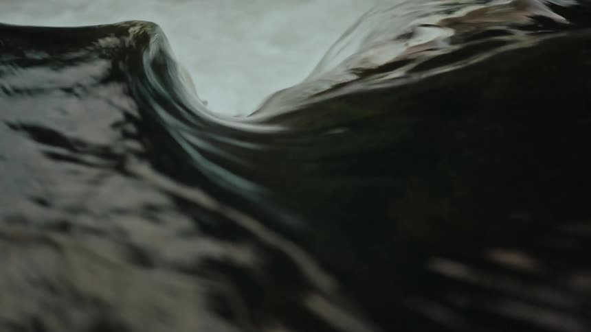 The turbulent water rushes over a rocky river surface