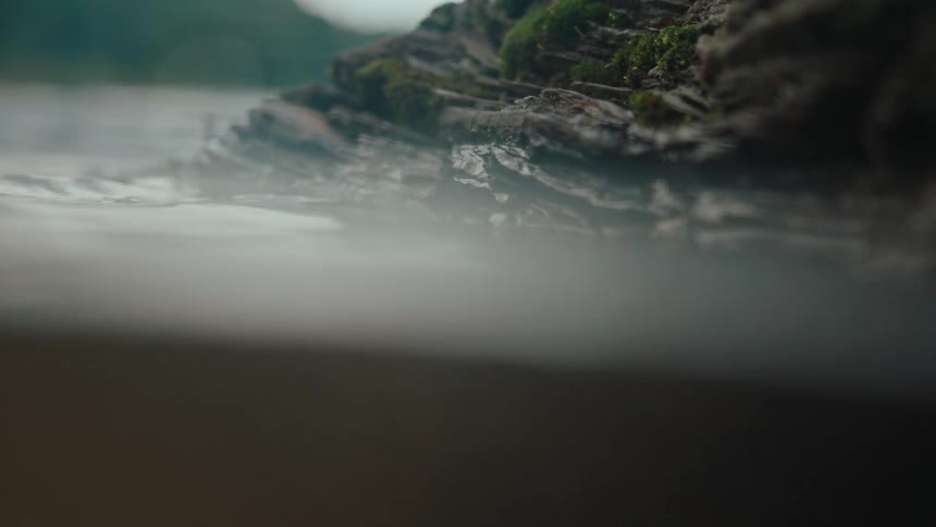 Waters of a river with small ripples at the edge of a rock
