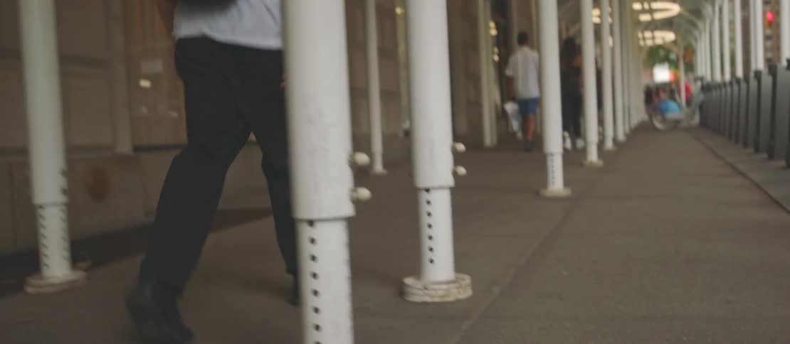 Man with backpack walking down a hallway in a public place