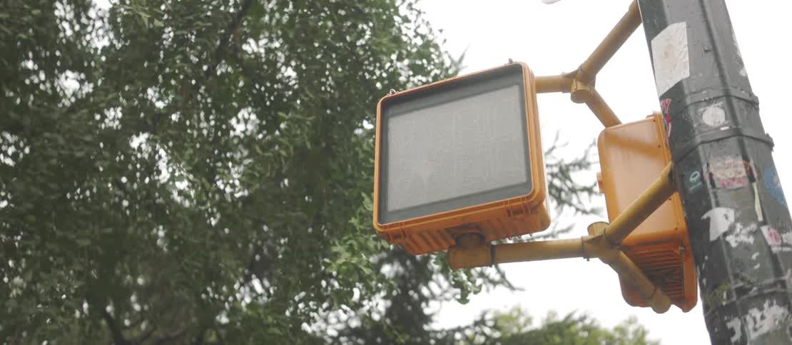 An electronic traffic sign flashing a red light in the shape of a hand