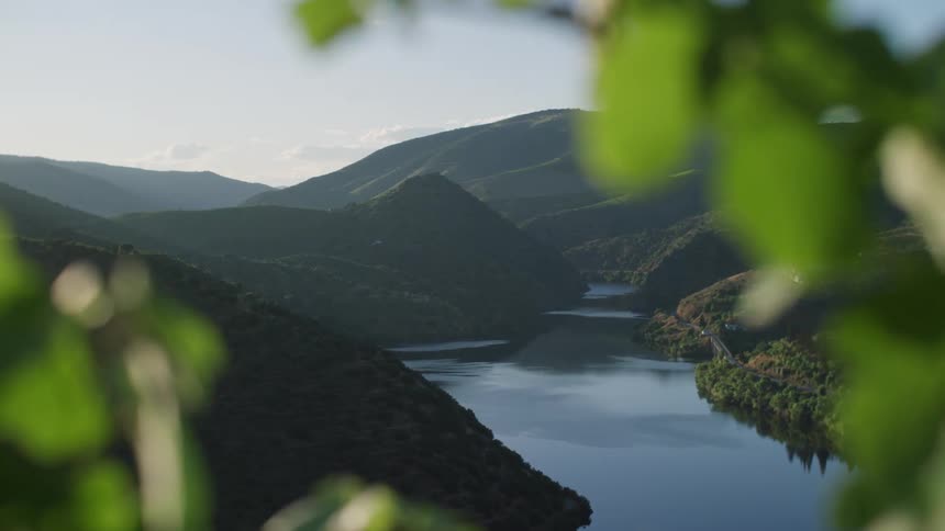 Green mountains surround a still lake on a sunny summer day