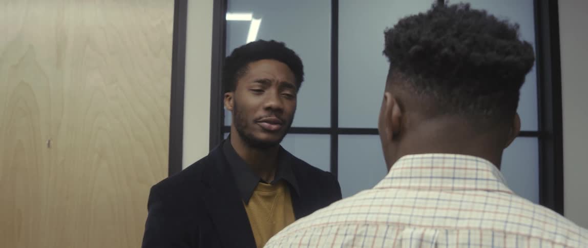 Two men in a work environment talking