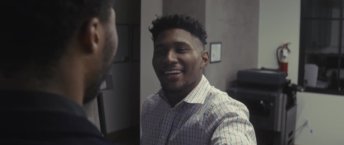 A coworker speaks to another employee in an office