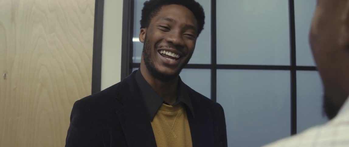 Two men in an indoor space talking