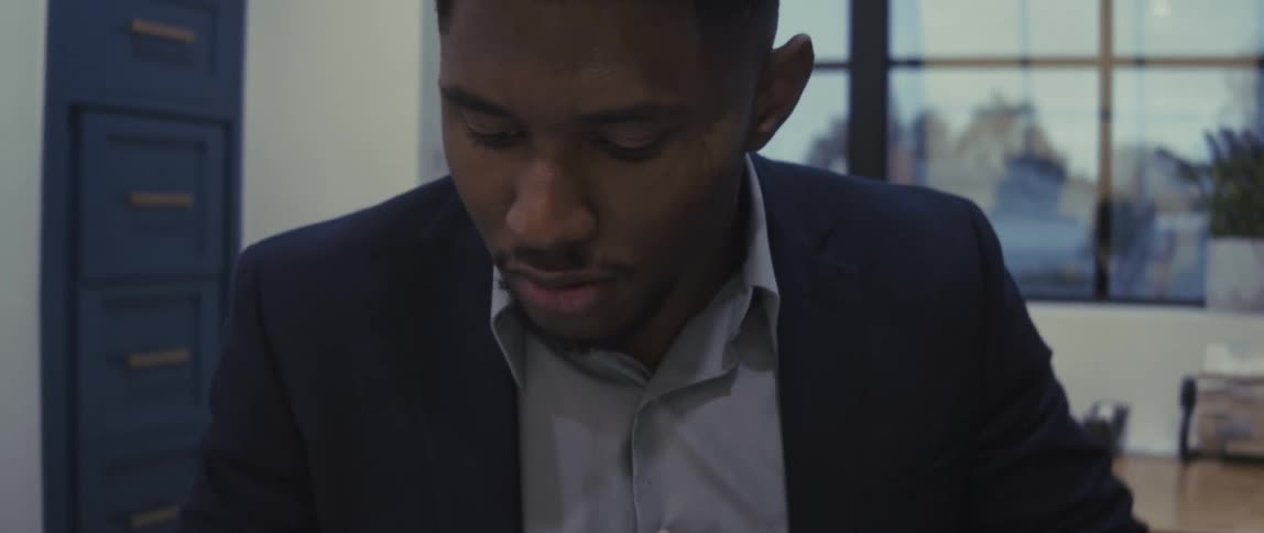 Man sitting in an office reading a document concentrated