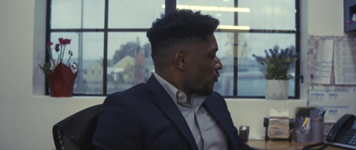 Office worker reviews notes while working at a desk near a window